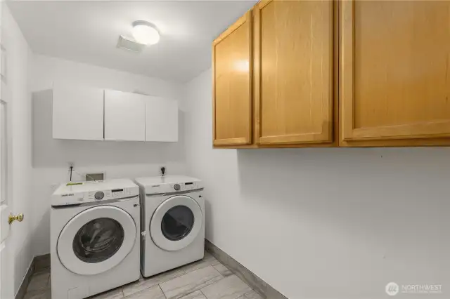 Brand new washer dryer in laundry and pantry room on the main floor with tiled floor matching kitchen floor