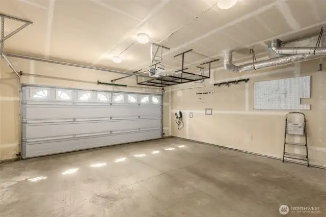 2 car garage with overhead storage shelf. EV car charger installed in garage.