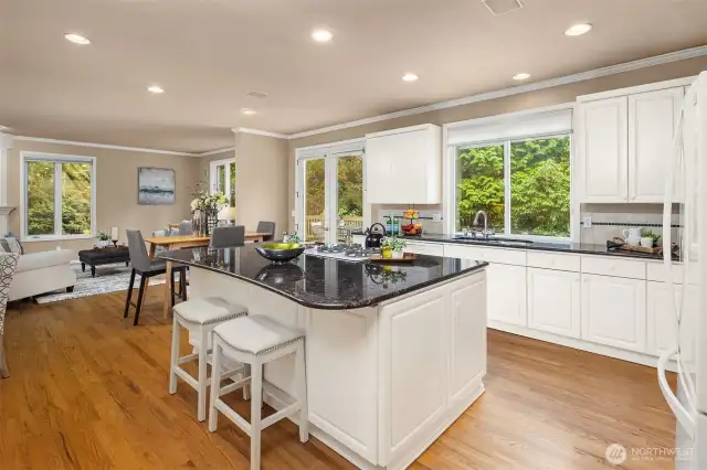 From the butler's pantry, welcome to the kitchen!  Bar seating, crisp white cabinetry with matching appliances, gas range and dual ovens, and the room opens up directly to the cozy family room.  What more do you need?!