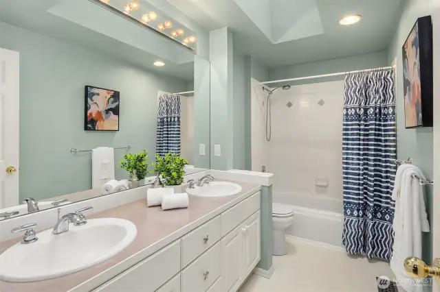 Upstairs full bathroom, with skylight, dual sinks, and shower/tub.