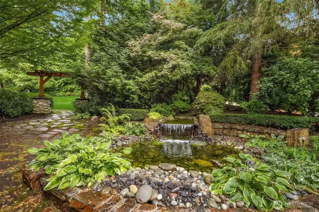 From the stacked stone fountain and the flagstone patio surround, head towards the archway to the vast, grassy, level lawn in front.