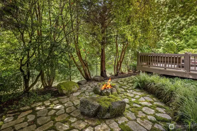 Also from the gazebo, looking back towards the hot tub area of the deck, you see the outdoor woodburning fire pit.  Elegant stone patios everywhere.  You simply must see.  Beyond the fence is a
