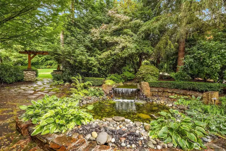 From the stacked stone fountain and the flagstone patio surround, head towards the archway to the vast, grassy, level lawn in front.