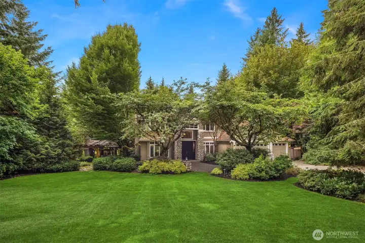 The lush yard showcases a rich variety of plantings, ornamental shrubs and mature trees. All-yard outdoor landscaping lighting by highly acclaimed Moonshadows Landscape Lighting, with lights in trees, up lighting, and lighting within the perimeters, creates a magical glow as soon as the sun goes down.