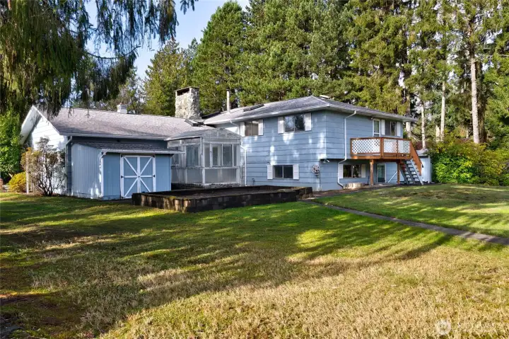 Backyard with raised garden beds and greenhouse.