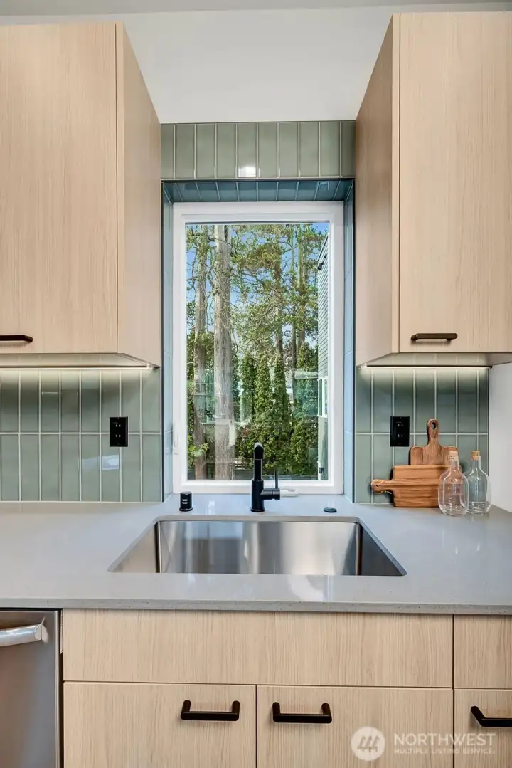 The kitchen window pulls nature in and is in sync with the calming natural palette of the home.