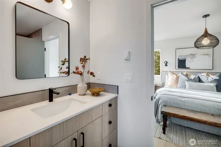 Primary suite ¾ bath with contrasting accents. The vanity provides extra storage with multiple drawers and ample under-cabinet space.