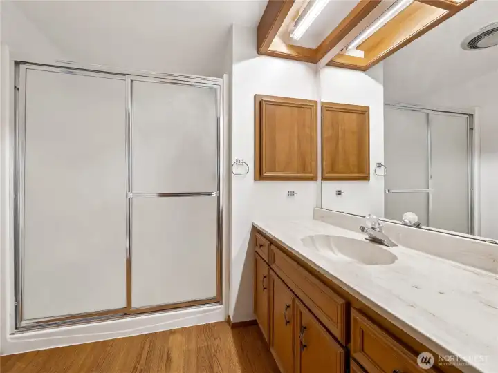 The primary bath has a large walk in shower and large vanity area with plenty of storage.