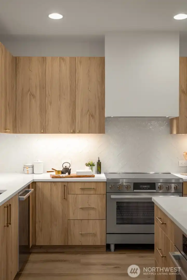 Custom Bellmont cabinetry, modern hardware, Calacatta quartz, and Bosch appliances with a 36” induction range.