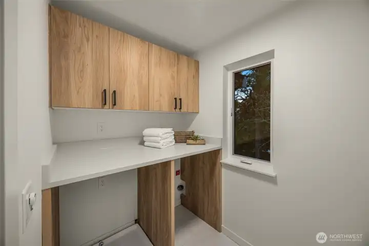 Upper laundry room with plenty of cabinet storage space.