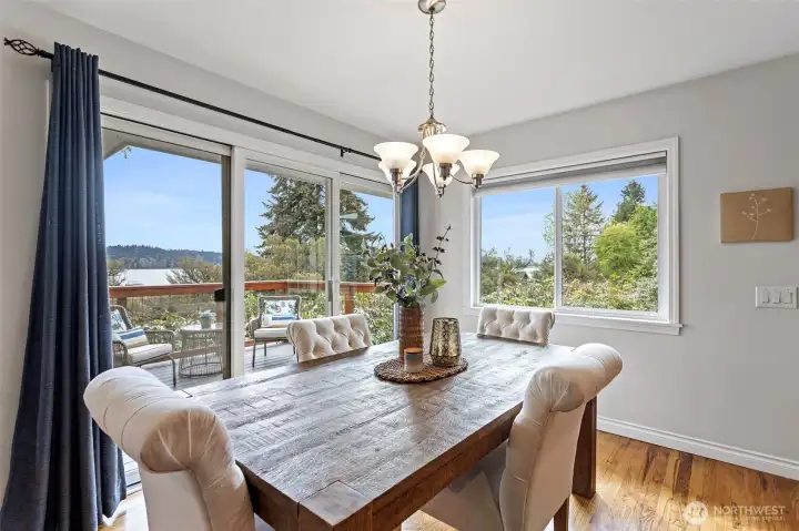 Dining area - Perfectly situated between the kitchen and access to the upper view deck, you would never want to eat out again! With windows all around it is surrounded by greenery.