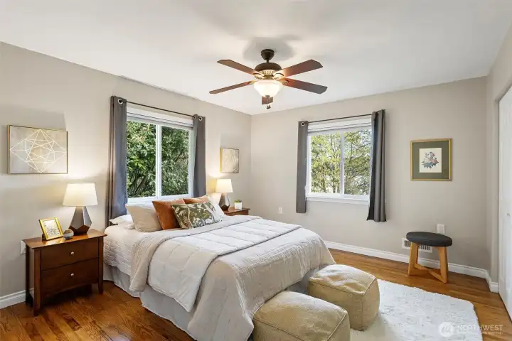 Primary bedroom with a view. Windows facing north and east to the lake. Beautiful oak floors, fresh paint and a ceiling fan for extra comfort.