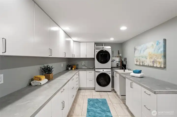 A wonderful surprise in the lower level with an extra large room that can be used for various purposes, such as a second kitchen, workshop, hobby room. With concrete countertops, tiled flooring, recessed lighting, lots of cabinets and drawers, this is a great space.