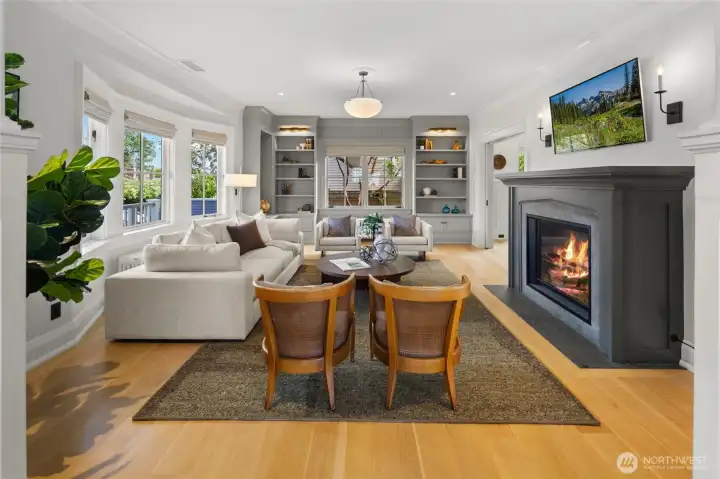 The sophisticated main floor offers elegant yet comfortable living spaces, including a beautifully appointed living room and stylish powder room accented with designer wallpaper, oak hardwoods, and another Shaw’s sink.