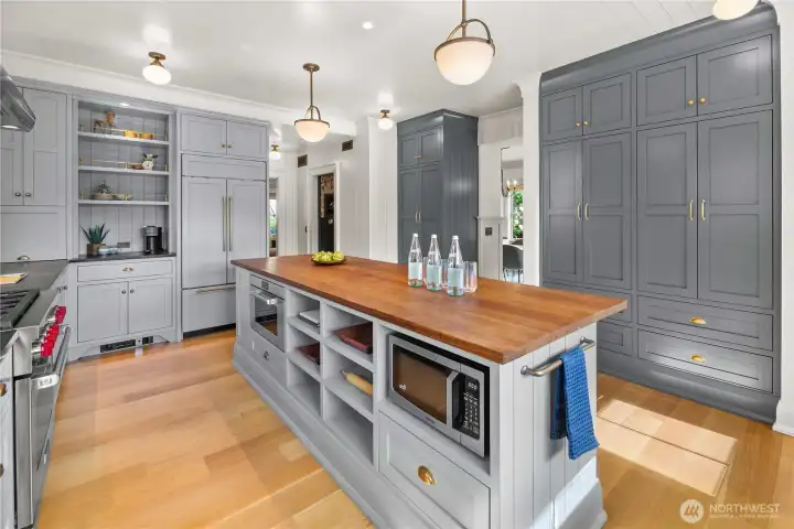 The stunning chef’s kitchen features an expansive walnut island, Wolf appliances, Sub-Zero refrigerator, soapstone counters, and a beautiful Shaw’s farmhouse sink, anchoring the home and flowing seamlessly into the dining room.