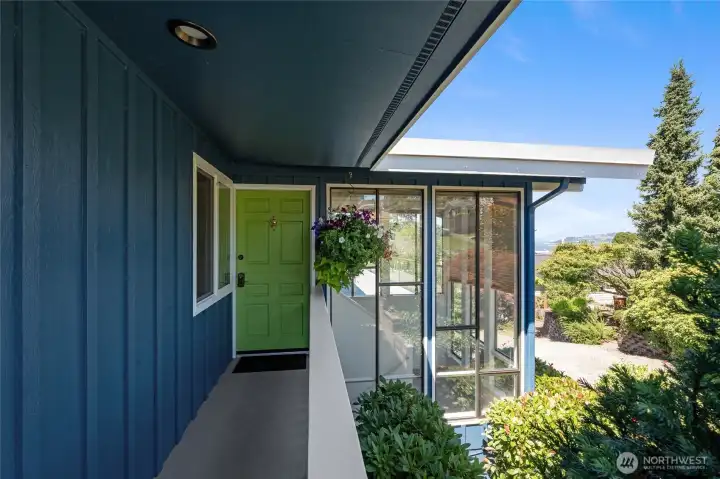 Covered walkway to the front Dutch Door, Lush landscaping with views in the distance.