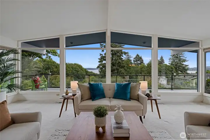 Living area framed by windows overlooks lush green areas to views.
