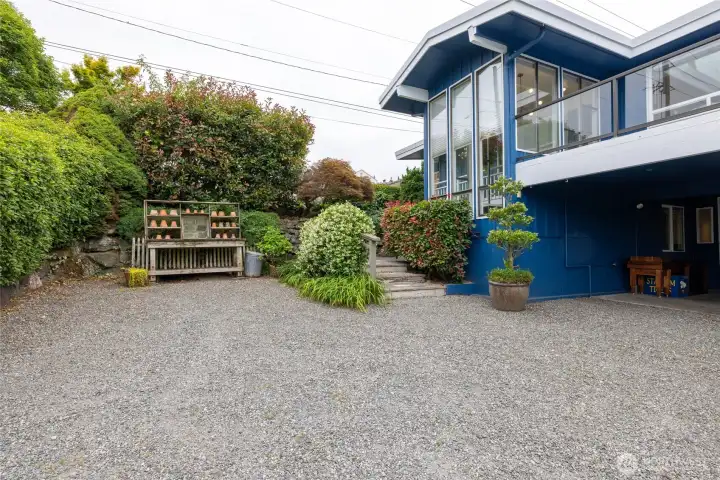 Side driveway with potting bench and stairs to the upper area of the lot.