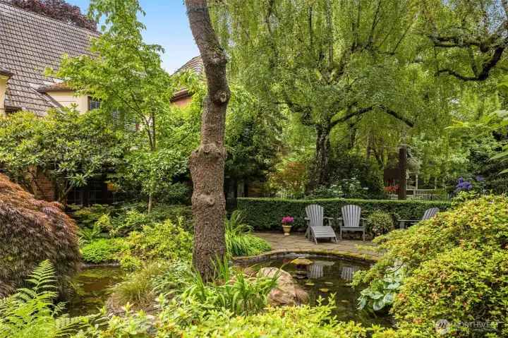 Under a mature tree canopy, follow the curved flagstone pathways around a lush English garden.
