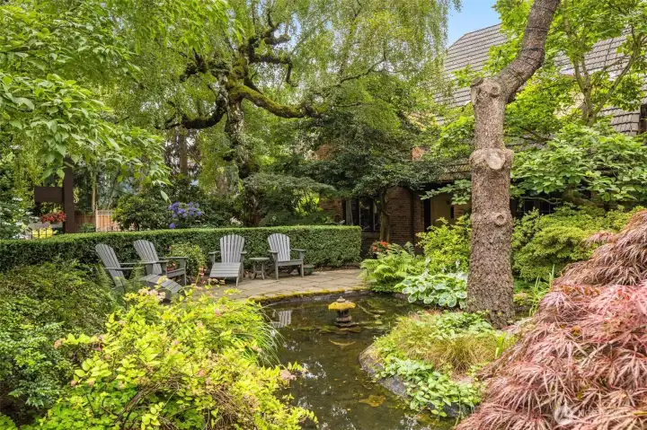 Wrapped in the courtyard is a beautiful pond, container gardens, and Adirondack chairs, perfect for enjoying the enchanting surroundings.