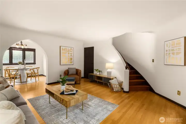 The generous living room features a view of the gracious curved staircase, with barrel-roll ceilings leading to the second floor.