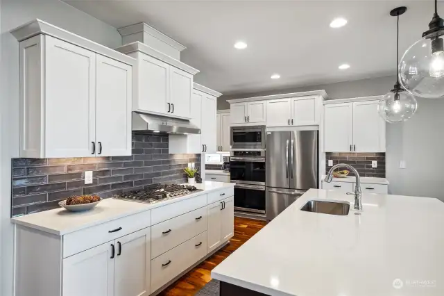 Experience culinary perfection in this stunning magazine-worthy kitchen with quartz countertops, elegant white cabinetry, and high-end stainless steel appliances.