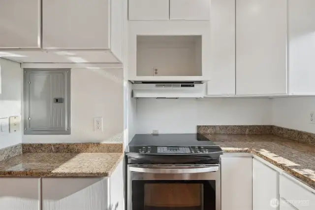 Nice bright kitchen with tall white cabinets and updated granite counters.