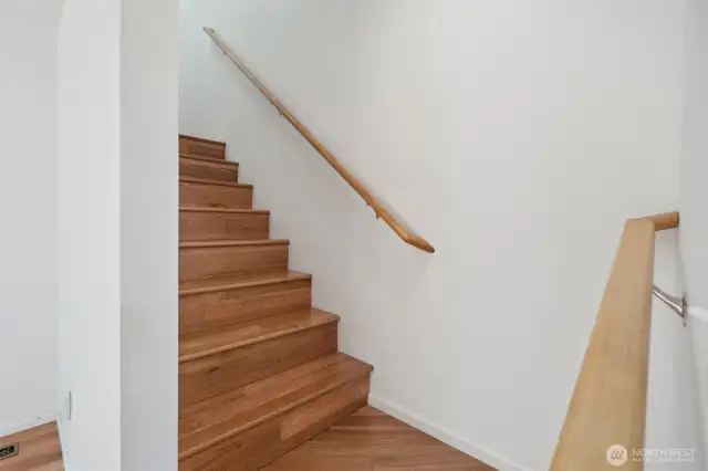 Wood stairs lead to the second level bedrooms and primary suite.