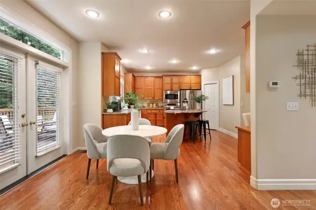 Sunlit breakfast nook nestled between the kitchen and family room, framed by large windows with serene backyard views—perfect for morning coffee or casual dining in natural light.