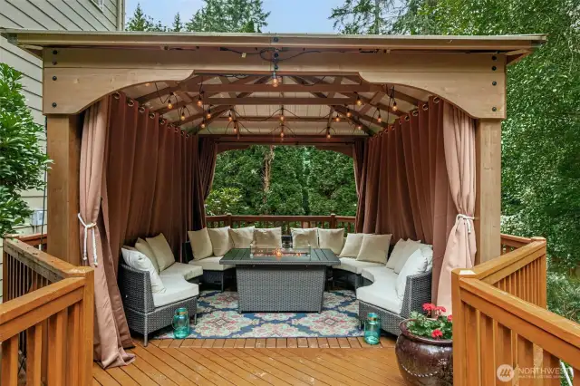 Enjoy the beautiful nature surrounding you year-round in this outdoor living space in the covered gazebo with a fire table. This deck also features additional support and is wired for a hot tub.