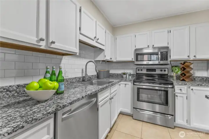 Updated kitchen with granite counters, stainless steel appliances, and subway tile backsplash.