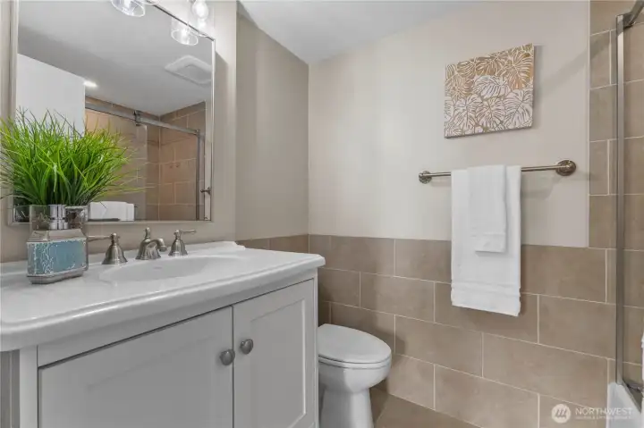 Modern bathroom with tiled walls, updated vanity, and sleek fixtures