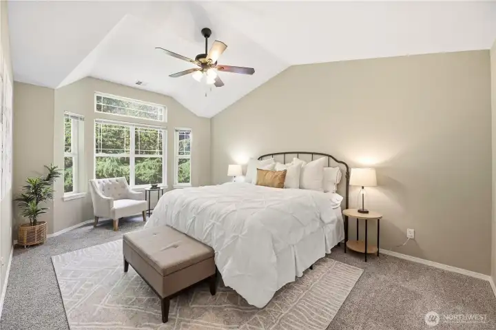 Spacious primary bedroom with oversized windows with greenbelt views