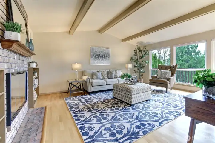 Vaulted ceilings and a dramatic wall of windows fill the living room with natural light, perfectly framing sweeping eastern territorial and mountain vistas.