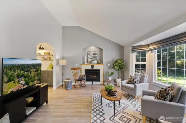 This light-filled living room invites you to unwind with vaulted ceilings and a modern fireplace that anchors the space.