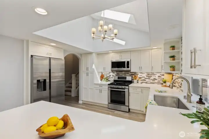 The tastefully updated kitchen features quartz counters, stainless steel appliances, brand new fridge, and abundant cabinetry, creating the perfect space for everyday living and creativity.