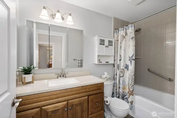 The guest bath features a stylish vanity, clean finishes, and a soaking tub for a spa-like feel.