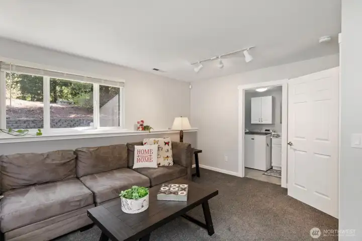 Bright lower-level living space, featuring convenient access to a 1/4 bath and laundry area.