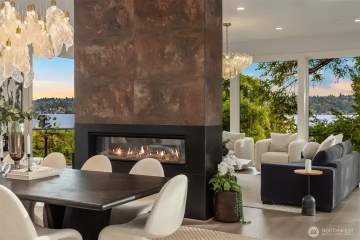 Designed for both connection and retreat, the dining and living areas are anchored by a striking double-sided fireplace. Formal gatherings flow naturally into relaxed conversation spaces, with walls of glass framing serene lake views and lush greenery