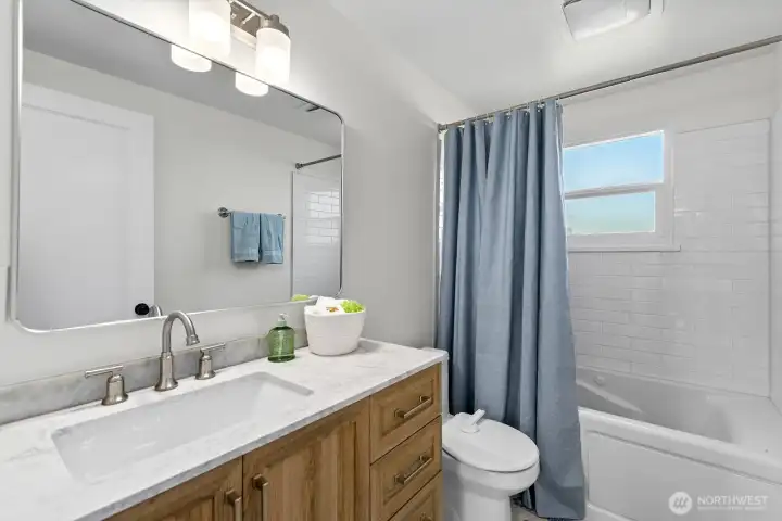 This is the main floor bath - it was remodeled to have a new, larger vanity and a jetted tub. There's also a cute white & blue tile floor.