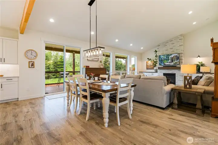 This generous dining area offers ample space for gatherings both large and small. The slider and oversized picture windows flood the room with natural light while beautifully bringing the outdoors in.