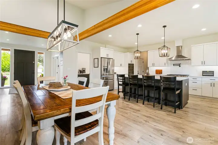 Dining room, kitchen and entryway with a peek-a-boo glimpse into the large walk-in pantry just ahead.