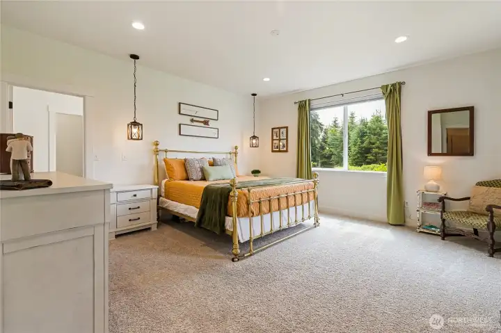 Spacious primary bedroom, thoughtfully positioned on the opposite end of the home from the two additional bedrooms, offering a peaceful retreat with ample room to relax and unwind.