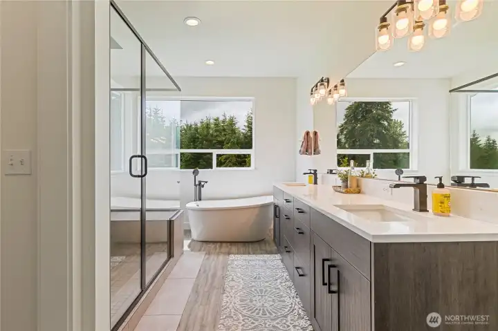 This spa-inspired primary ensuite is designed for ultimate relaxation, featuring a large soaking tub and a walk-in shower with dual shower valves for both a standard shower head and a rain shower experience.
