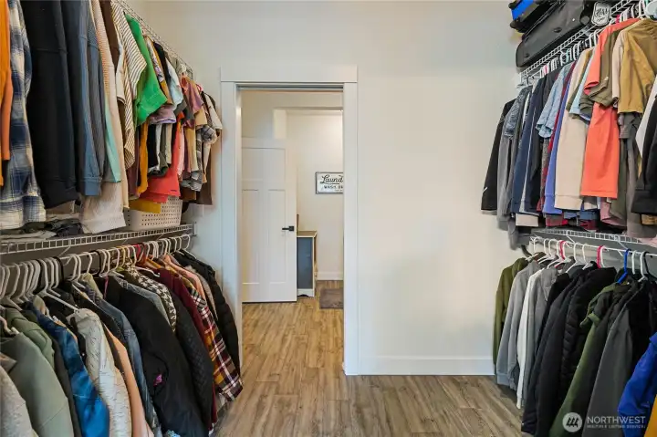Large primary Walk-in closet looking towards laundry and mud room.