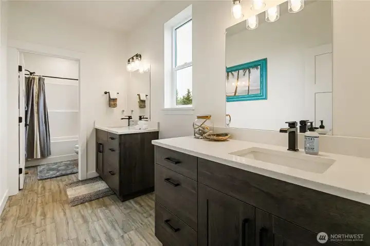 full bathroom with dual vanities located near the 2 additional bedrooms