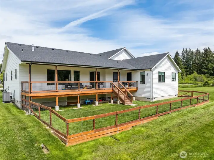 Rear elevation showcasing the expansive covered deck. The right-side bump-out highlights the primary bedroom, complete with a private door providing direct access to the deck.