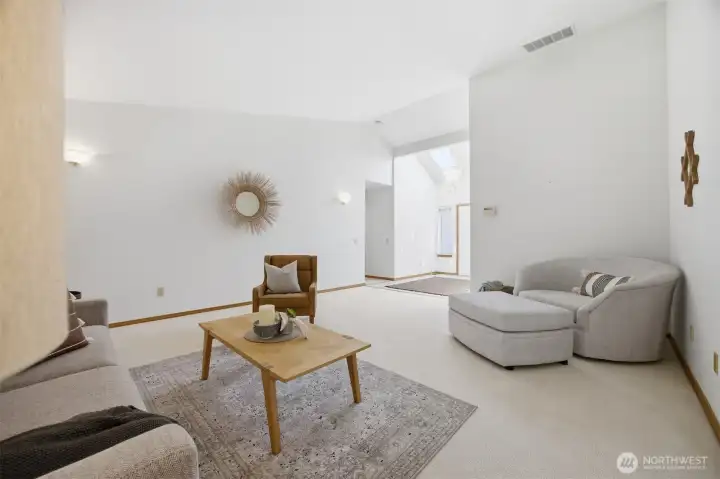 Looking across the living room toward the entry and hallway that leads to the bedrooms and baths.