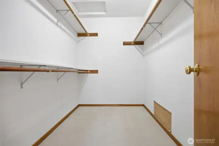 The walk-in closet is very spacious and holds a lot of clothing.