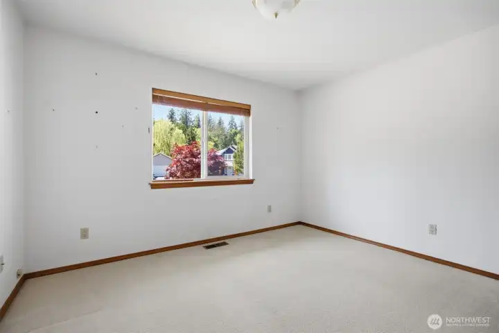The second bedroom looks out toward the front of the home and the cul-de-sac beyond.